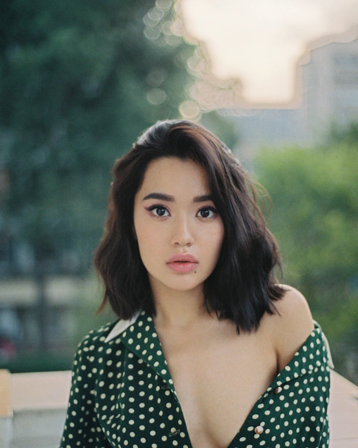 Woman with dark hair in a patterned top, sample portrait